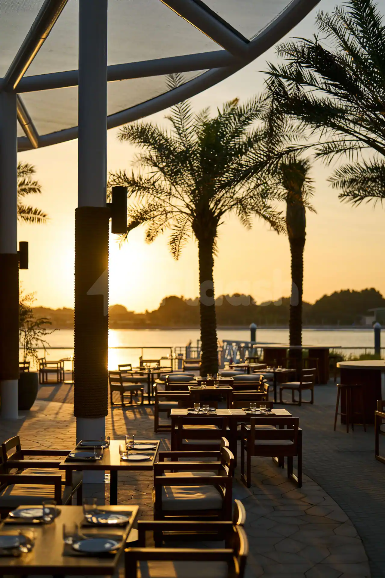 Rooftop terrace at Ergon Deli & Cafe Abu Dhabi with palm trees and sunset water view