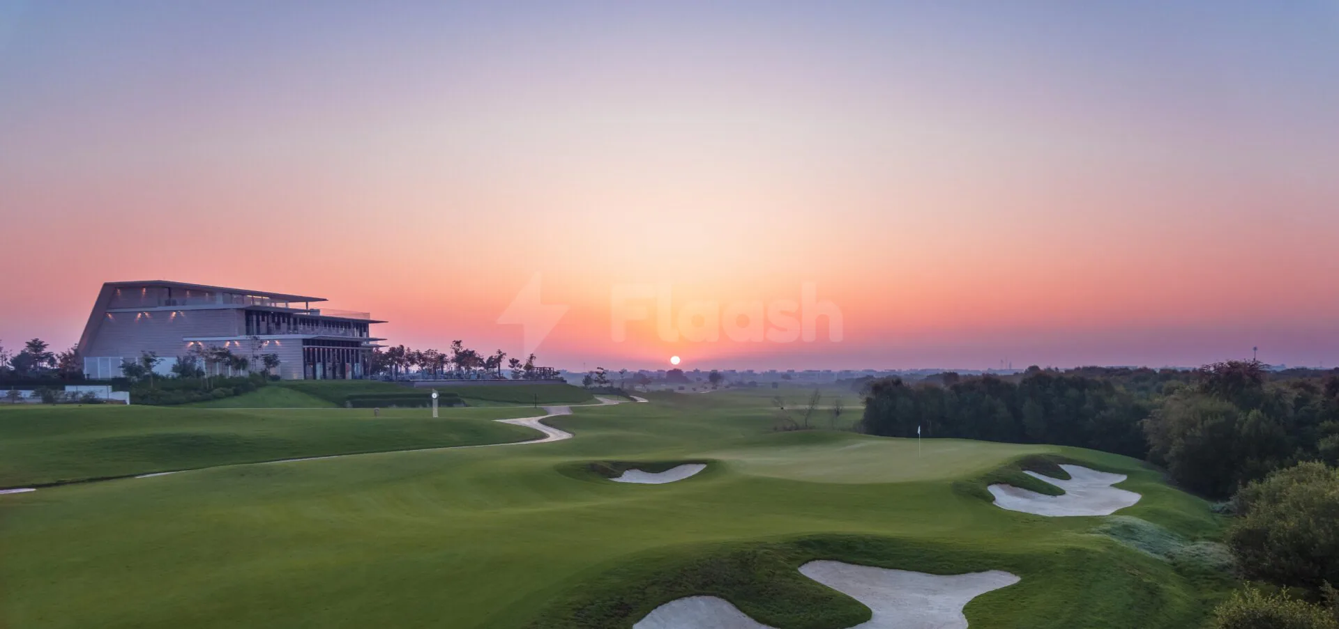 Golf course at Al Zorah Golf Club in Ajman with sand bunkers and sunset sky