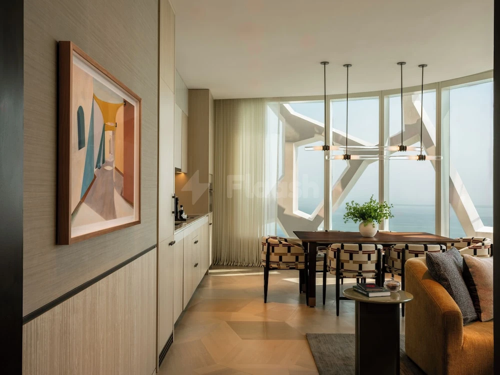Dining area at Rosewood Doha, Lusail, with geometric window frames and modern pendant lights over wooden table