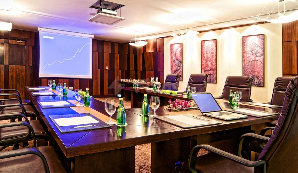 Meeting room at Grand Regal Hotel, Doha, with wooden panel walls and a large conference table set for