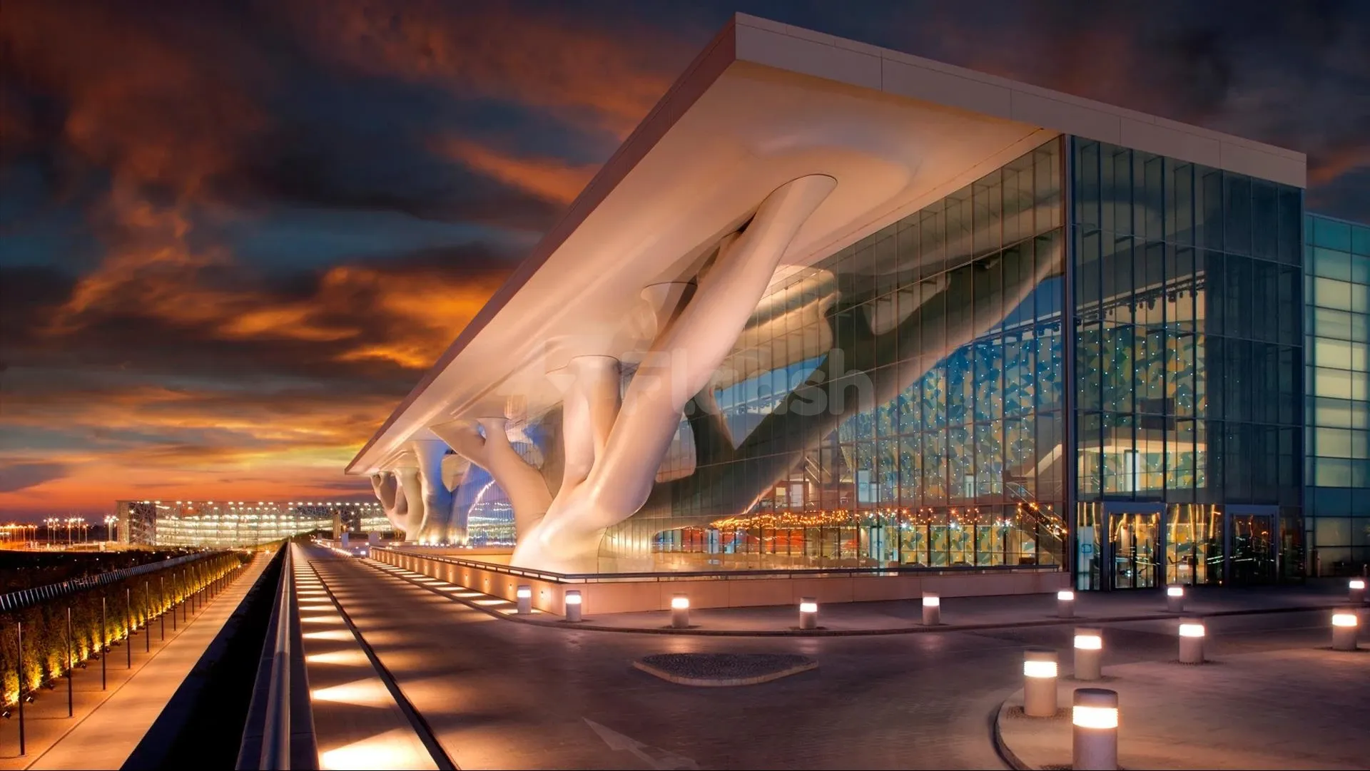 Modern convention center at Qatar National Convention Centre, Doha, featuring sculptural white columns and expansive glass facade illuminated