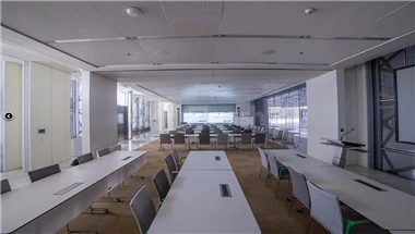 Meeting room at Doha Exhibition and Convention Center, Doha, with longed tables and modern chairs under bright ceiling