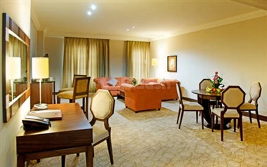 Living room at Swiss-Belhotel Doha, Doha, with orange sofa and wooden furniture
