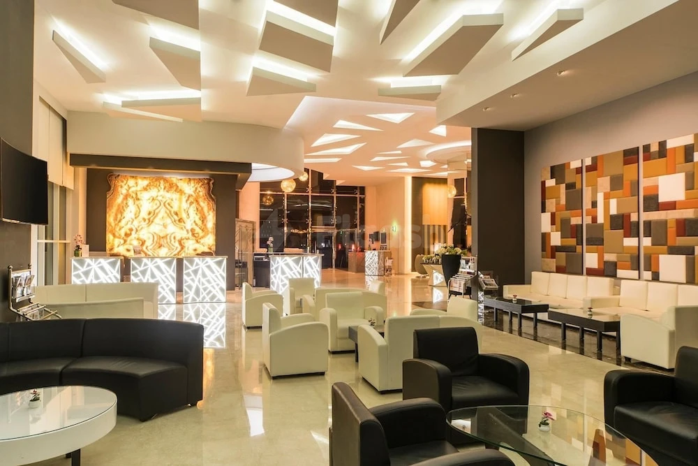 Lobby at Best Western Plus Doha, Doha, featuring geometric ceiling lights and colorful mosaic wall art