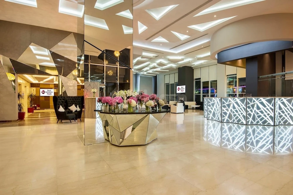 Lobby at Best Western Plus Doha, Doha, featuring geometric ceiling lights and mirrored floral centerpiece