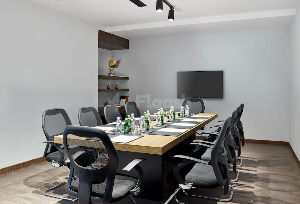 Conference room at Staybridge Suites Doha Lusail, Lusail, with wooden table and wall-mounted screen
