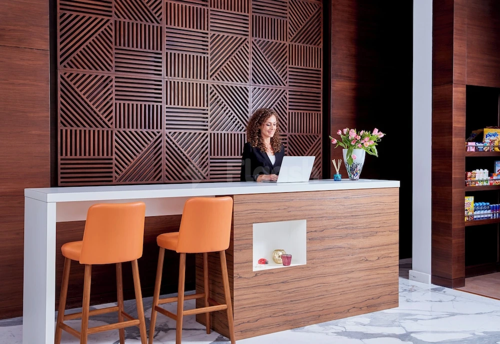 Lobby bar at Staybridge Suites Doha Lusail, Lusail, with geometric wood paneling and orange stools