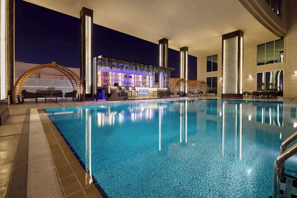 Indoor swimming pool at Double Tree by Hilton Doha - Al Sadd, Doha, with blue mosaic tiles reflecting ambient