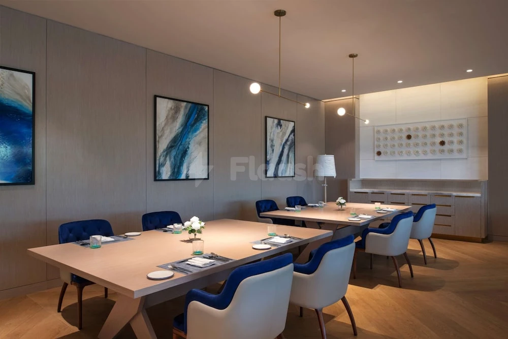 Boardroom at Steigenberger Hotel Doha, Qatari capital, with blue-accented chairs and abstract wall art