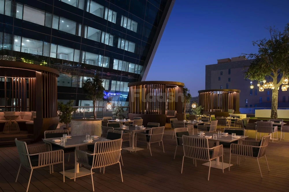 Outdoor terrace at Steigenberger Hotel Doha, Doha, featuring wooden cabanas and ambient lighting under evening sky
