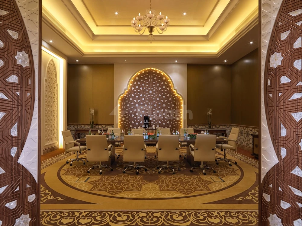 Boardroom at Marsa Malaz Kempinski, Doha, with arched illuminated wall panel and patterned wooden doors