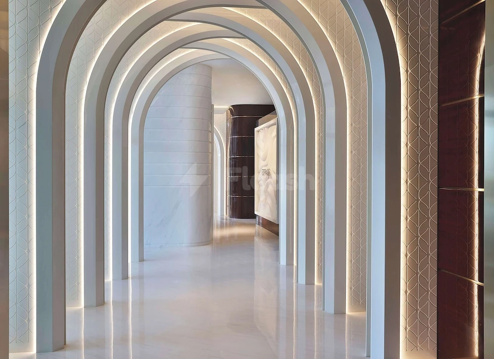 White marble arches illuminated by soft lighting at Waldorf Astoria Doha Lusail, Lusail – Doha, with geometric wall patterns