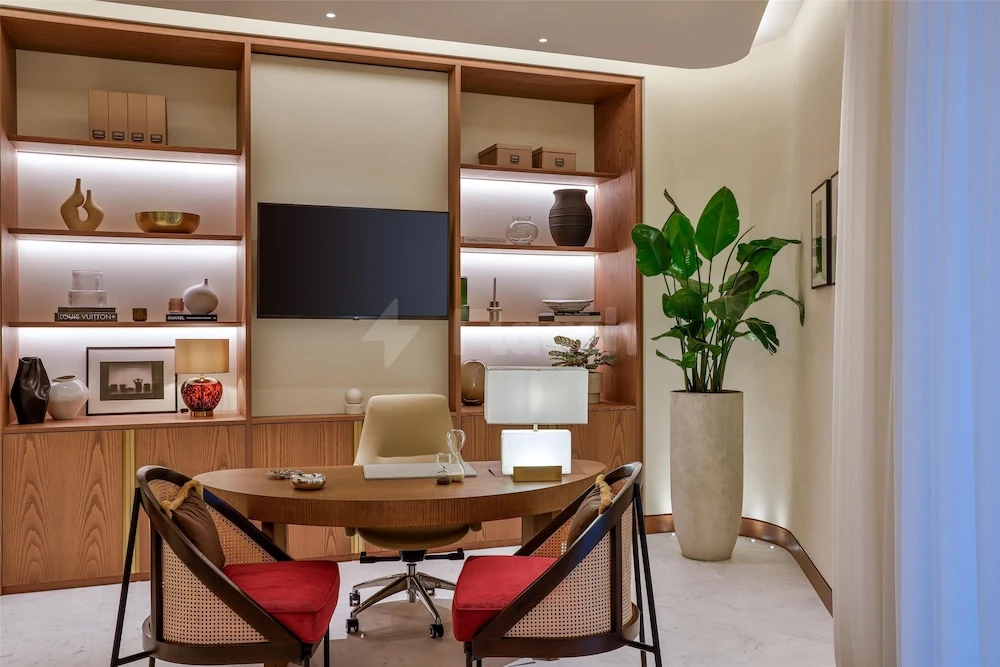 Workspace at Waldorf Astoria Doha Lusail, Lusail – Doha, with wooden shelving and red cushioned chairs