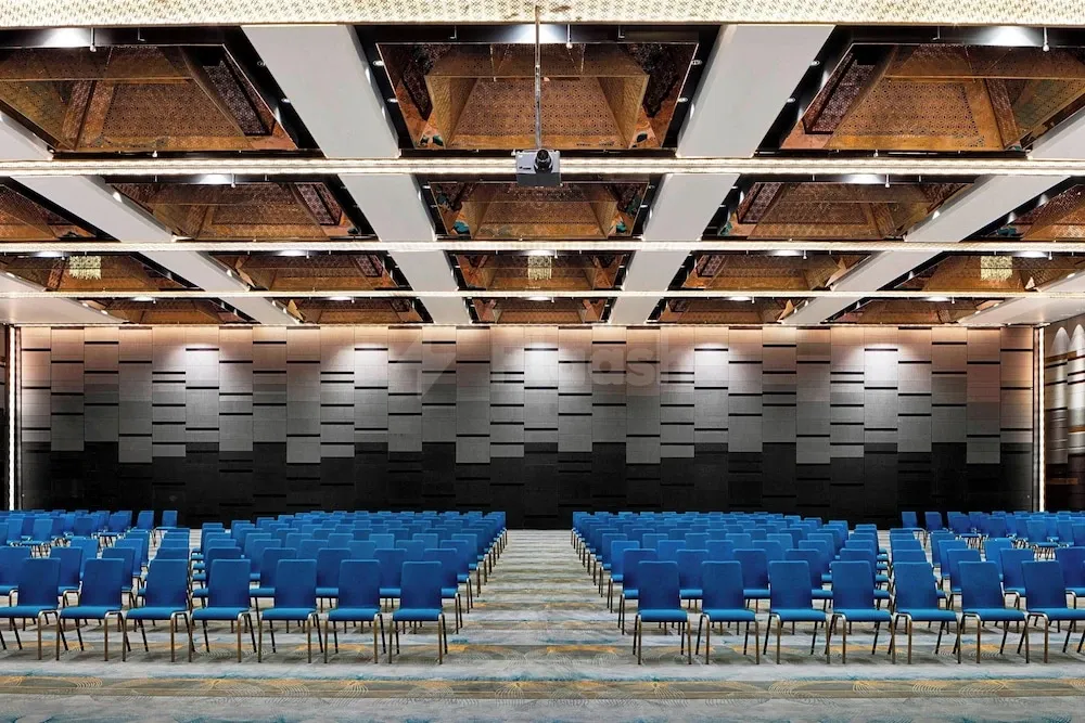 Ballroom at The Westin Doha Hotel & Spa, Doha, with blue chairs and geometric wall panels under patterned ceiling