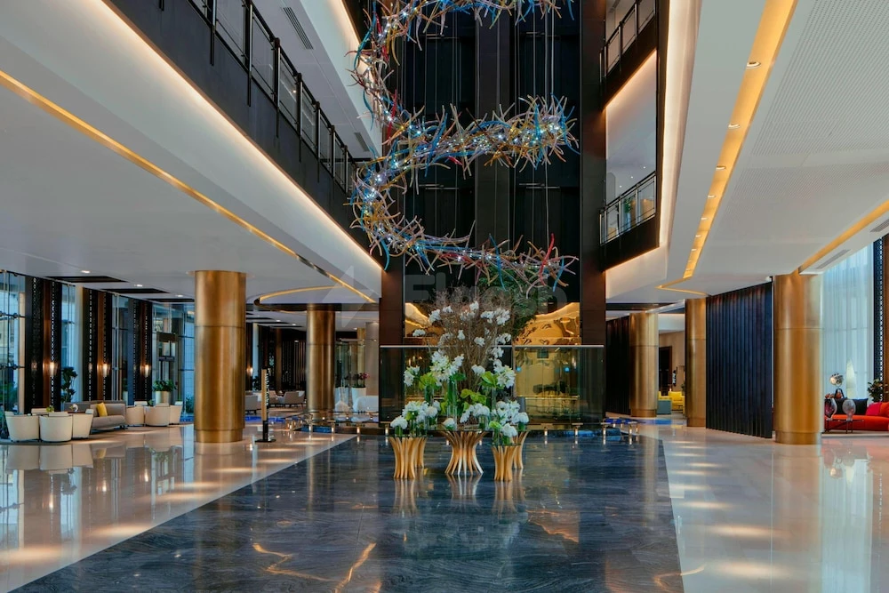 Grand lobby at The Westin Doha Hotel & Spa, Doha, featuring a colorful spiral sculpture and polished marble floors