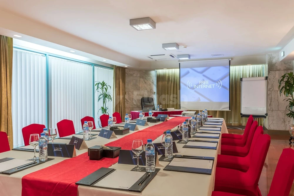 Conference room at Radisson Blu Hotel, Doha, with red chairs and projection screen displaying free internet