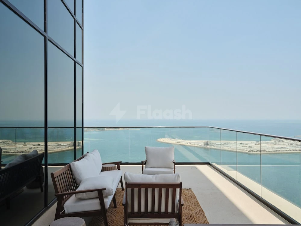 Terrace at The OQ Hotel, Lusail, featuring wooden loungers and glass railings overlooking the sea