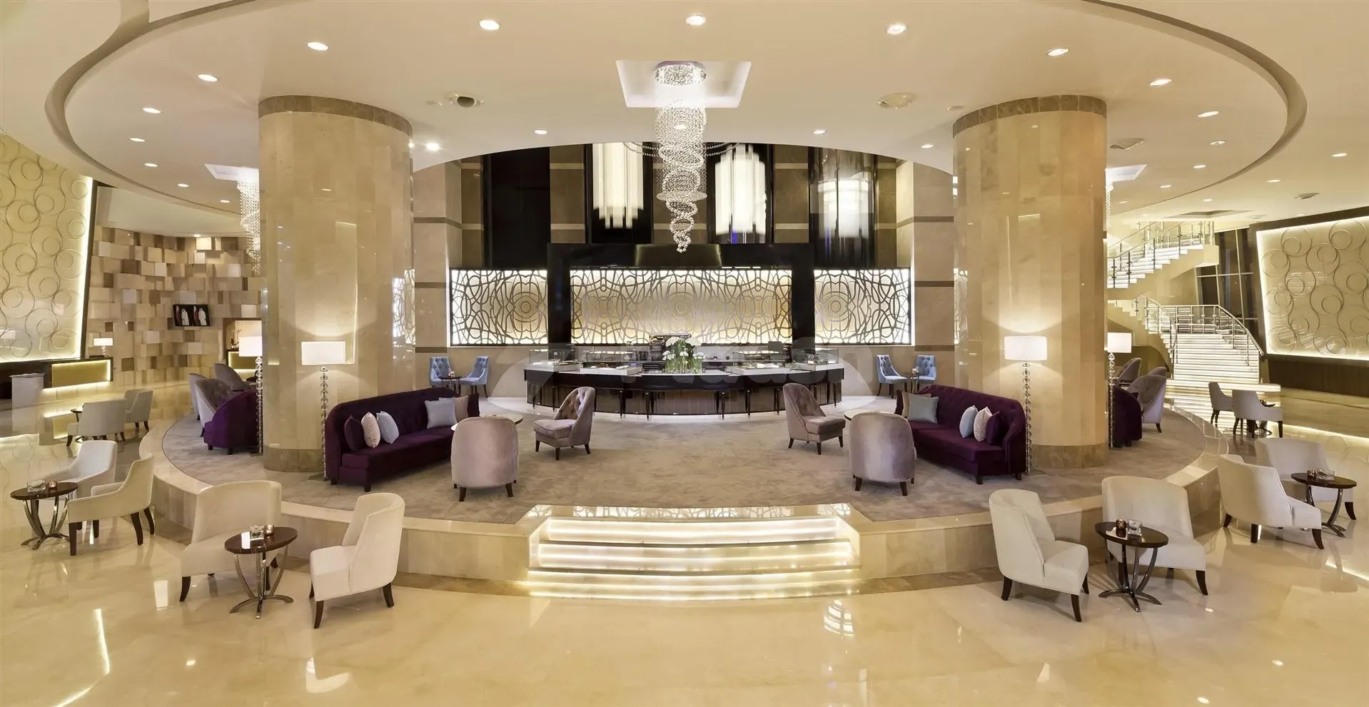 Lobby at Melia Doha, Doha, featuring marble columns and a spiral chandelier over plush seating areas