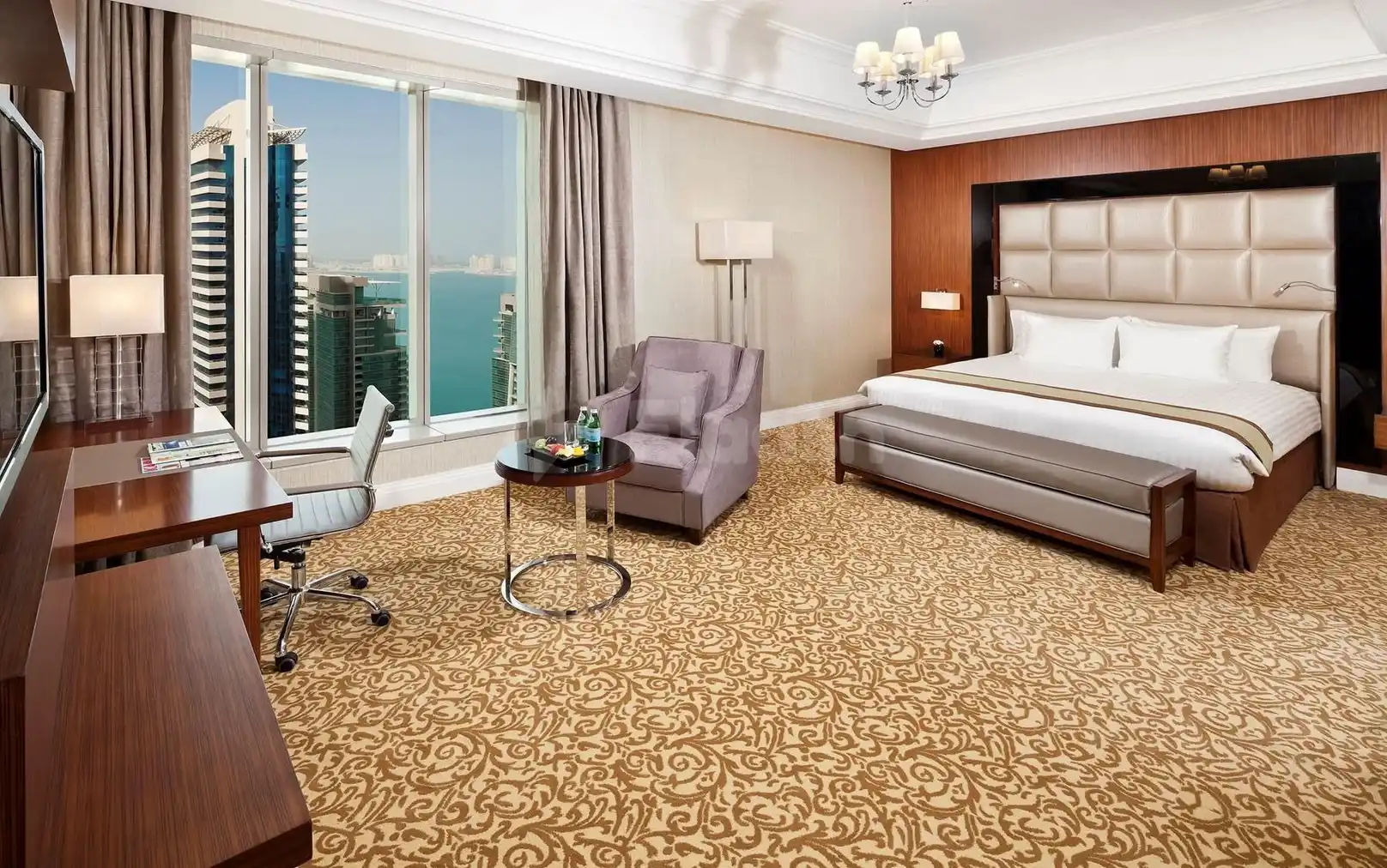 Luxury guest room at Melia Doha, Doha, featuring city skyline views through floor-to-ceiling windows and a plush