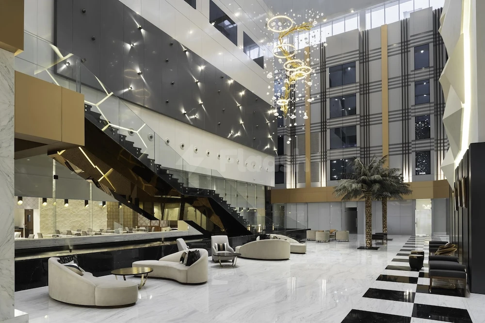 Grand lobby at Radisson Blu Hotel and Residence Riyadh D.Q., featuring a towering golden chandelier and sleek