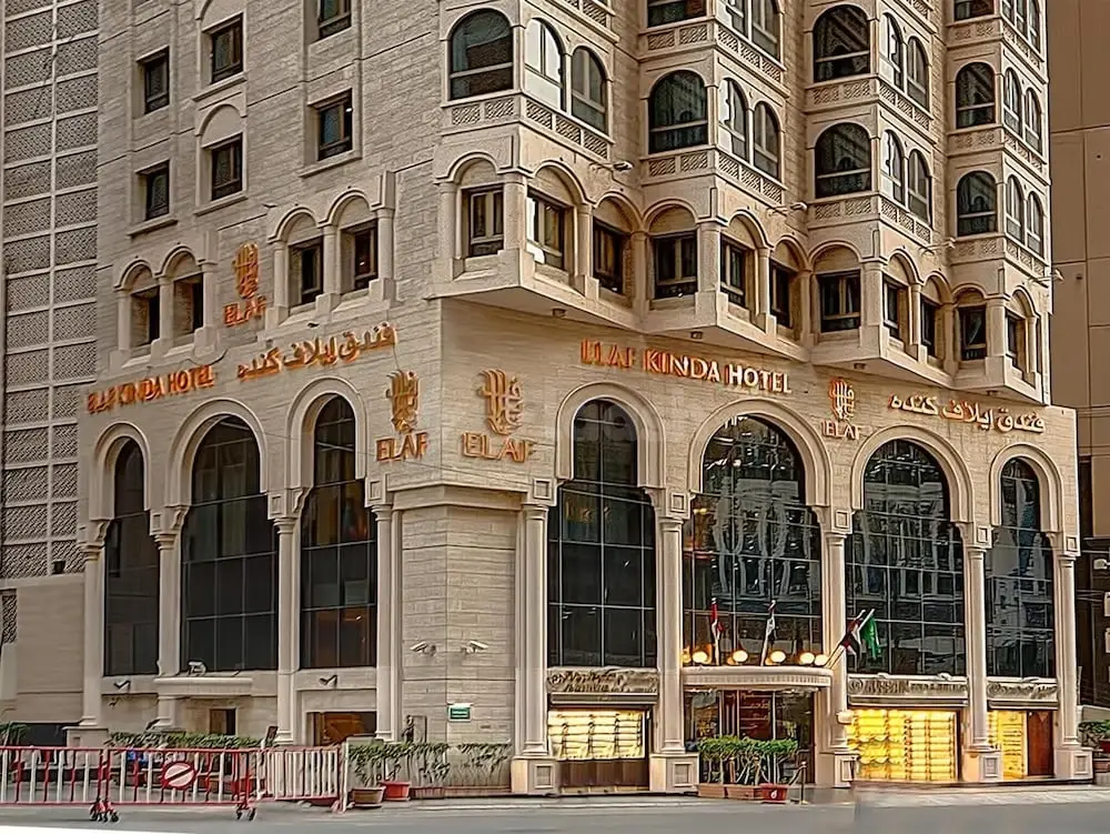 Grand facade at Elaf Kinda Hotel, Mecca, featuring arched windows and golden signage