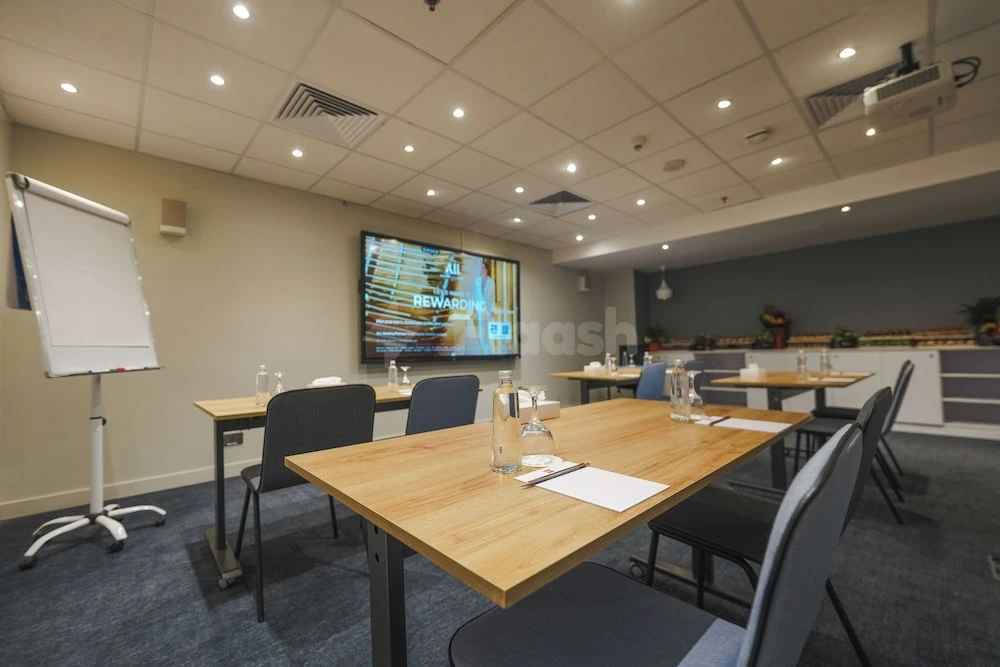Meeting room at ibis Jeddah City Center, Jedd 3, with wooden tables and large screen display