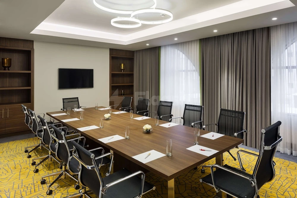 Conference room at Park Inn by Radisson Makkah Aziziyah, Makkah, with wooden table and circular ceiling lights