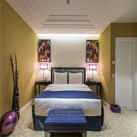 Bedroom at Vivienda Residence, Riyadh, with abstract wall art and purple accent lamp