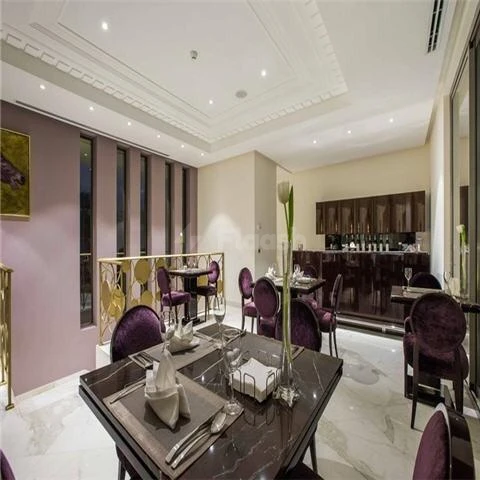 Dining area at Vivienda Residence, Riyadh, featuring purple chairs and marble tables under recessed lighting