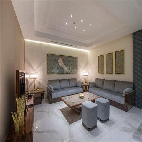 Living room at Vivienda Residence, Riyadh, featuring marble flooring and framed artwork above sofas