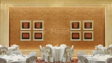 Banquet hall at Le Méridien Towers Makkah, featuring white linen-draped tables by tables and framed artwork