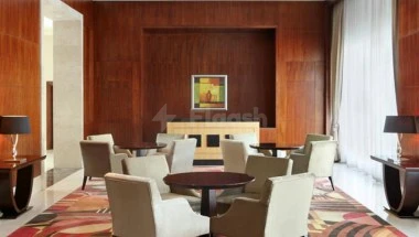 Lounge area at Le Méridiengether Towers Makkah, featuring warm wood paneling and a central artwork