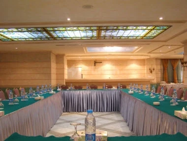 Banquet hall at Sunset Jeddah, Jeddah, with stained-glass ceiling and green tablecloths
