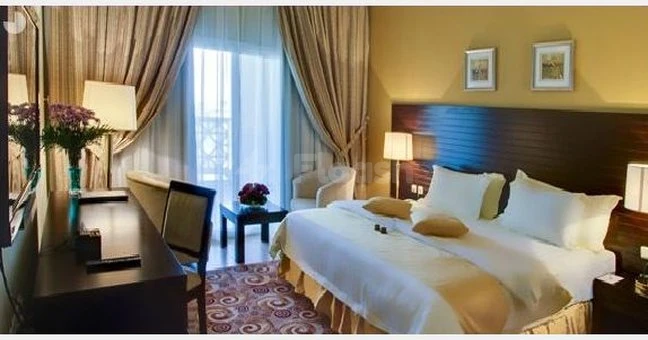 Hotel room at Boudl Half Moon Resort, Khobar, with large bed and patterned carpeting