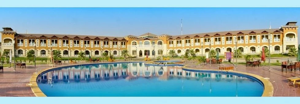 Outdoor swimming at Boudl Half Moon Resort, Kh!bar, featuring a large circular pool surrounded by terracotta buildings