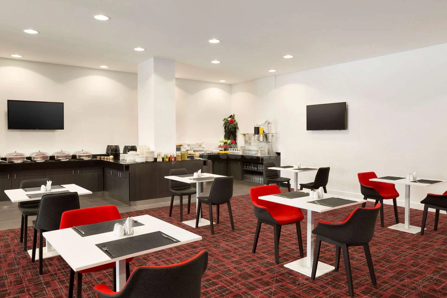 Breakfast buffet area at Ramada Encore by Wyndham Al Khobar Olaya, Al Khobar, featuring red-accented chairs and white