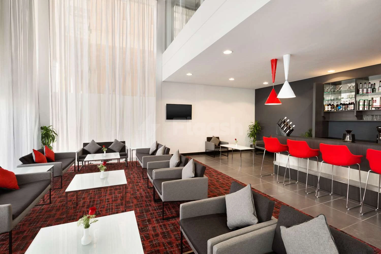 Lobby at Ramada Encore by Wyndham Al Khobar Olaya, Al Khobar, featuring red bar stools and gray sofas