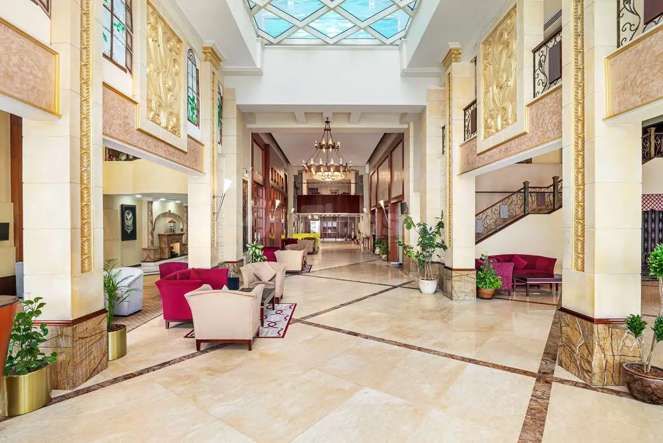 Grand atrium lobby at Ramada by Wyndham Dammam Khaleej Road, Dammam, featuring marble columns and a glass ceiling
