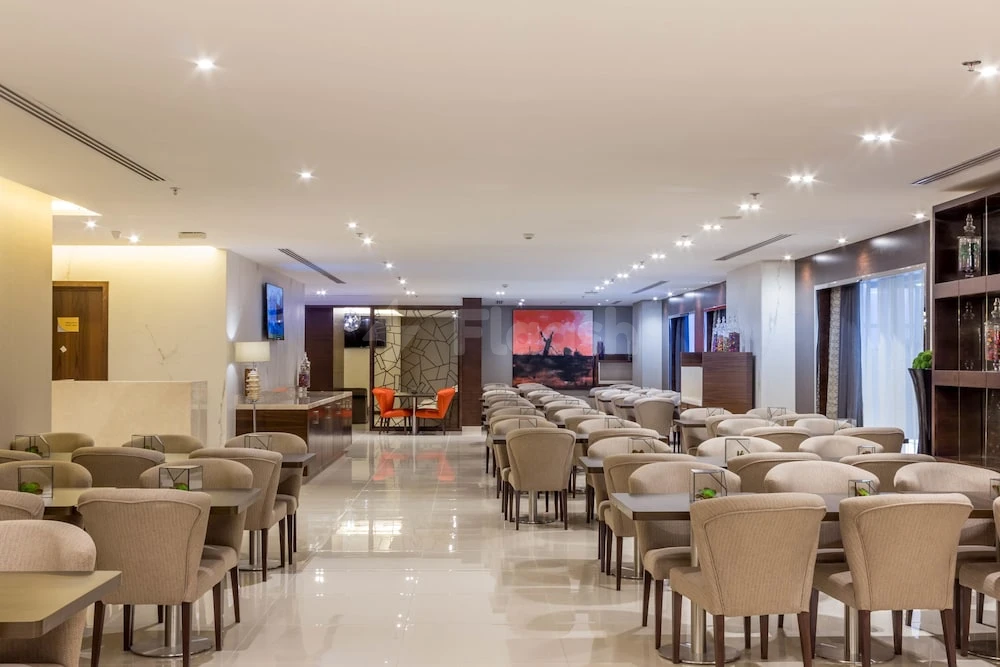 Dining area at M Hotel Makkah By Millennium, Mecca, with polished floors and modern seating arrangement