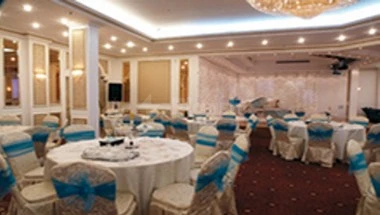 Banquet hall at Al Azhar Hotel Jeddah, with round tables draped in white linens and blue sashes