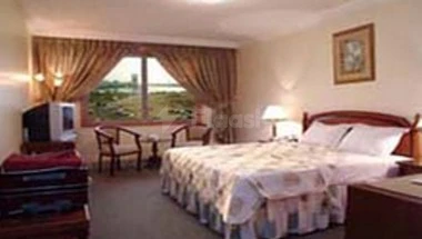 Guest room at Al Azhar Hotel Jeddah, Jeddah, featuring a large bed with patterned linens and window seating