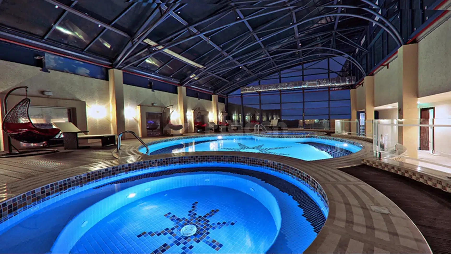 Indoor pool at Casablanca Grand Hotel, Jeddah, featuring tiered circular design and star mosaic under glass roof