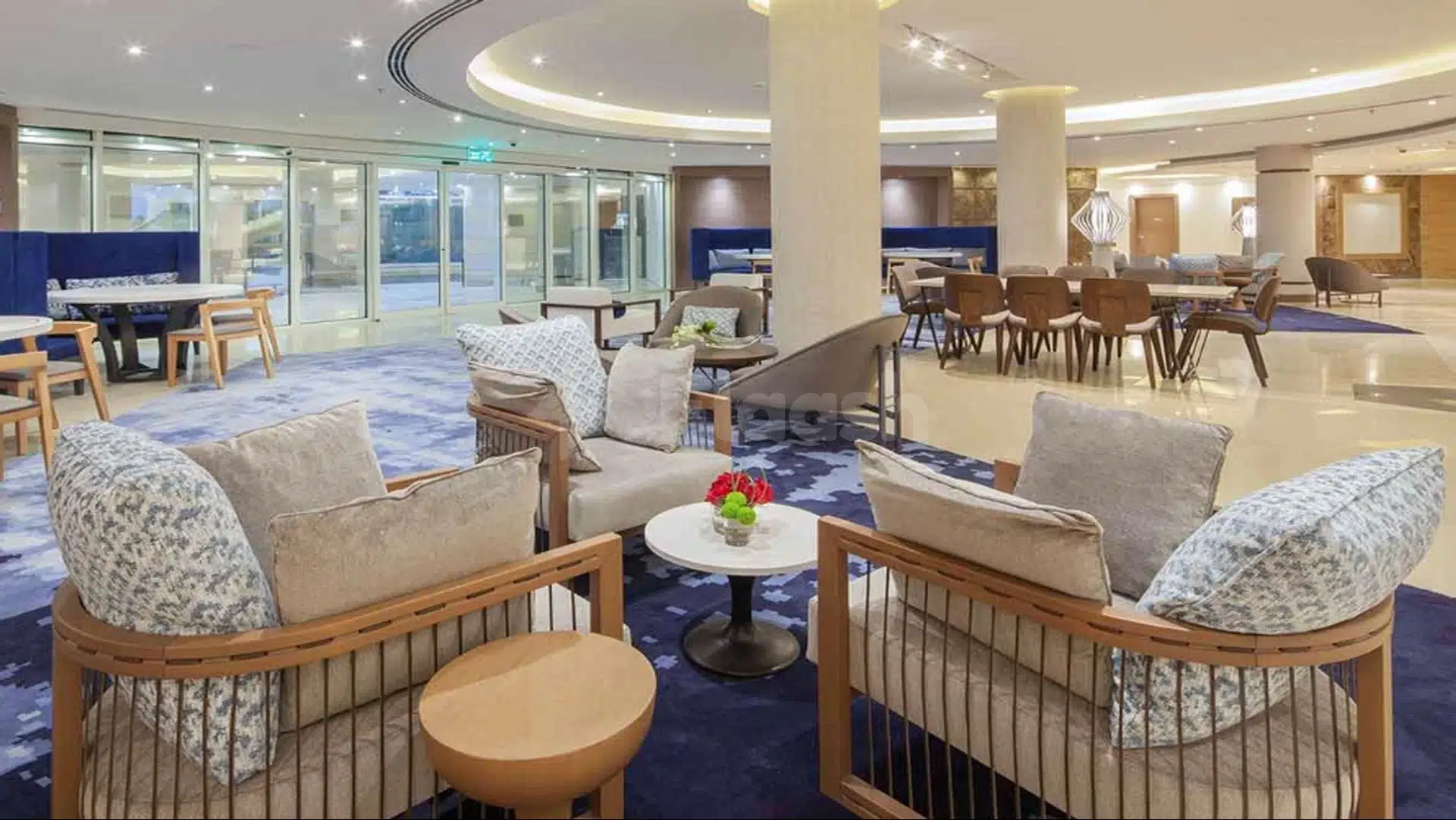 Lounge area at Radisson Blu Resort Al Khobar Half Moon Bay, Al Khobar, featuring wooden armchairs and blue