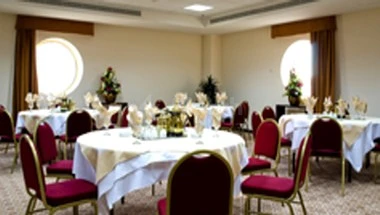 Banquet hall at Makarim Al-Baitt Hotel, Mecca, with round tables set for dining under soft lighting and large