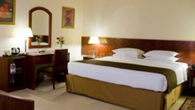Guest room at Makarim Al-Bait Hotel, Mecca, featuring, with wooden headboard and bedside lamps