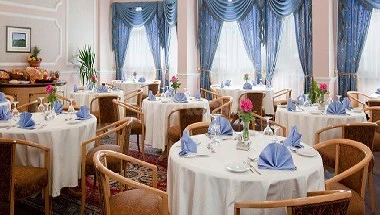 Dining area at Gloria Inn Najran, Najran, with blue curtains and white tablecloths