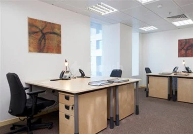 Modern office space at Regus - Dammam Business Park, Dammam, featuring wooden desks and abstract wall art