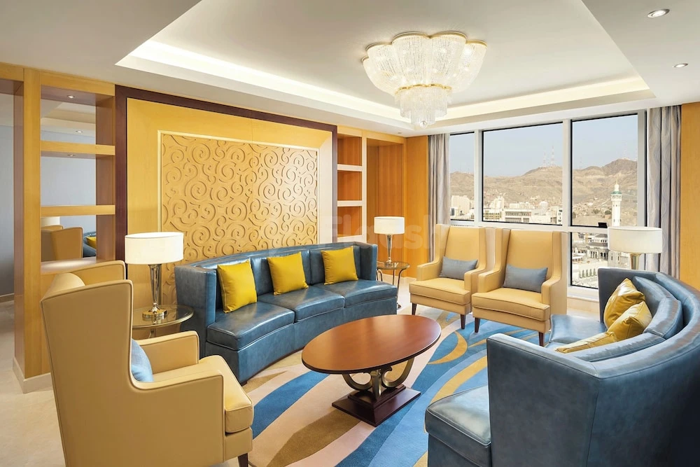 Lounge at Sheraton Makkah Jabal Al Kaaba Hotel, Makkah, with blue velvet seating and mountain views through large
