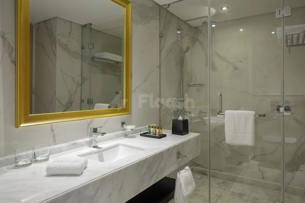Marble bathroom at Sheraton Makkah Jabal Al Kaaba Hotel, Makkah, with gold-framed mirror and glass shower enclosure