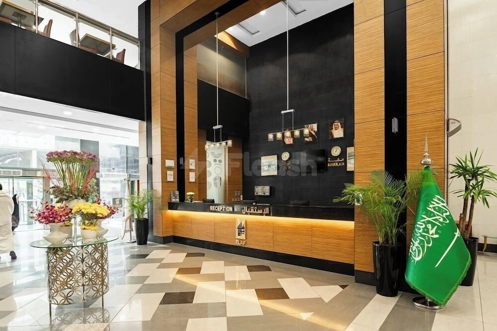 Lobby at Elaf Bakkah, Mecca, featuring wooden paneling and Saudi flag